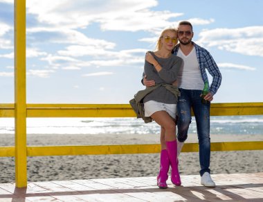 Sonbahar boyunca boş sahil barında birlikte bira içen çift.