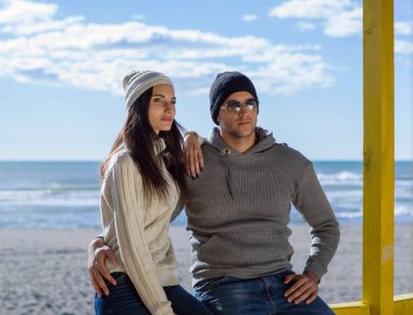 Mutlu çift, sonbahar günü kumsalda birlikte vakit geçiriyorlar.