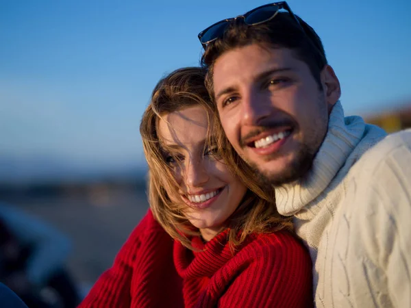 秋天阳光普照的一对年轻夫妇在海滩上玩乐的肖像 — 图库照片