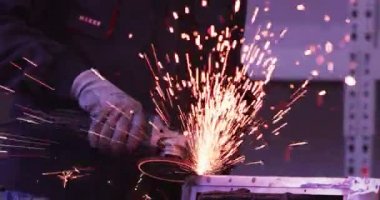 ağır çekimde fabrika küçük işletme dükkanda Bileme çelik yapı ve yapım sanayi işçisi elektrikli tekerlekli kıvılcım