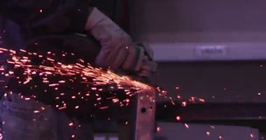 ağır çekimde fabrika küçük işletme dükkanda Bileme çelik yapı ve yapım sanayi işçisi elektrikli tekerlekli kıvılcım