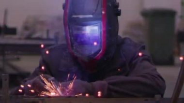 ağır çekimde fabrika küçük işletme dükkanda Bileme çelik yapı ve yapım sanayi işçisi elektrikli tekerlekli kıvılcım