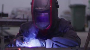 ağır çekimde fabrika küçük işletme dükkanda Bileme çelik yapı ve yapım sanayi işçisi elektrikli tekerlekli kıvılcım