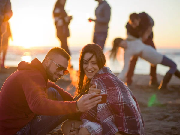 Paar Met Behulp Van Mobiele Telefoon Tijdens Herfst Strandfeest Met — Stockfoto