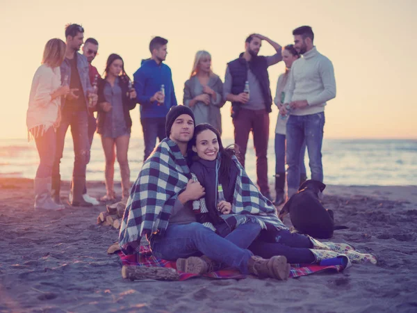 Pareja Joven Sentada Con Amigos Alrededor Campfire Beach Atardecer Bebiendo — Foto de Stock