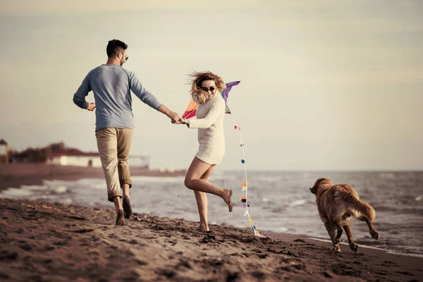 Pareja Joven Divirtiéndose Jugando Con Perro Cometa Playa Día Otoño —  Fotos de Stock