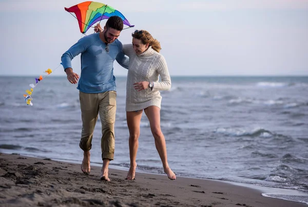 Pareja Joven Divirtiéndose Jugando Con Una Cometa Playa Día Otoño —  Fotos de Stock