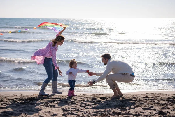 秋の日にはビーチでカイトと一緒に休んで楽しむ子供たちを持つ若い家族 — ストック写真