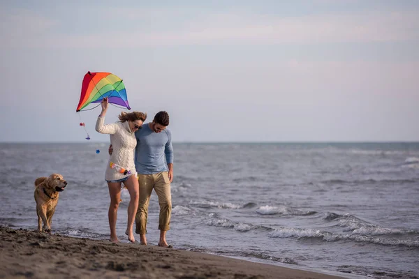 若いカップルが楽しんで犬 秋の日にビーチにカイトで遊んで — ストック写真