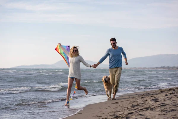 Genç Çift Eğlenmek Bir Köpek Sonbahar Günü Plaj Uçurtma Ile — Stok fotoğraf