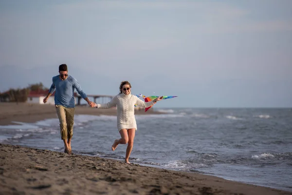 在秋天的一天 一对年轻夫妇在海滩玩起了风筝 玩得很开心 — 图库照片
