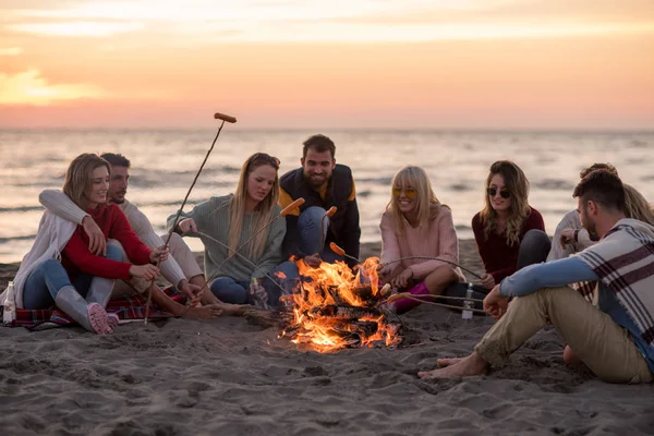 Grupo Jóvenes Amigos Sentados Junto Fuego Playa Otoño Asando Salchichas — Foto de Stock