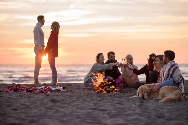 Casal Jovem Curtindo Com Amigos Redor Fogueira Praia Pôr Sol — Fotografia de Stock