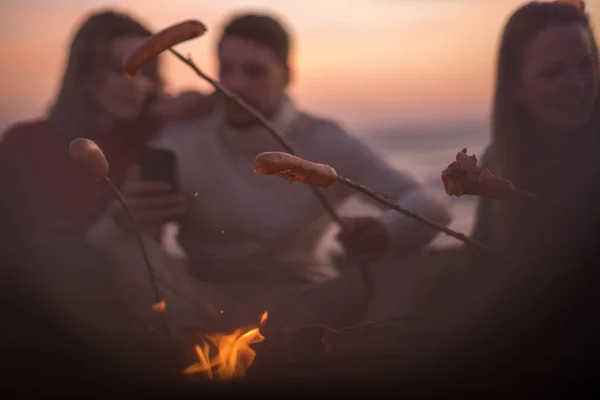 Groep Jonge Vrienden Bij Het Vuur Het Herfststrand Worstjes Grillen — Stockfoto