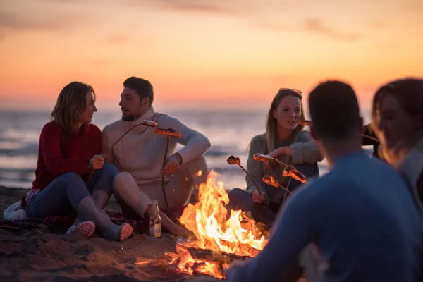 Grupo Jovens Amigos Sentados Lado Fogo Praia Outono Grelhando Salsichas — Fotografia de Stock