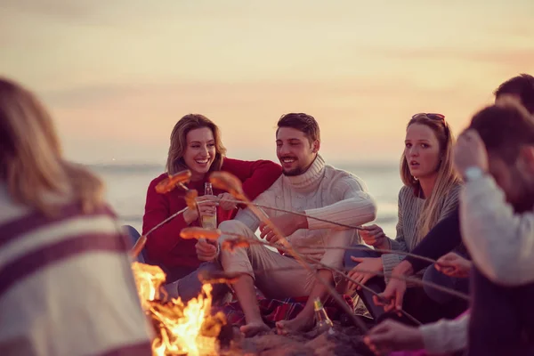 Gruppo Giovani Amici Seduti Accanto Fuoco Sulla Spiaggia Autunnale Grigliando — Foto Stock