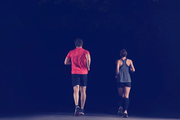 都会の公園でジョギングをしている健康な人たちや夜のトレーニングで — ストック写真