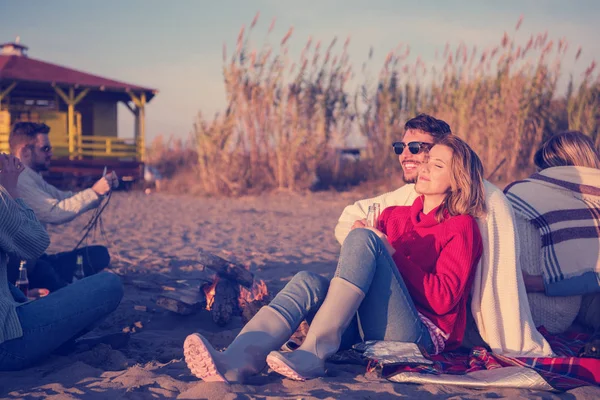 Fiatal Pár Élvezi Barátaival Körül Tábortűz Strandon Naplementekor Sört Iszik — Stock Fotó