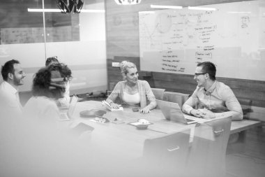 Bir grup genç iş adamı modern ofis binasında iş planlarını tartışıyor