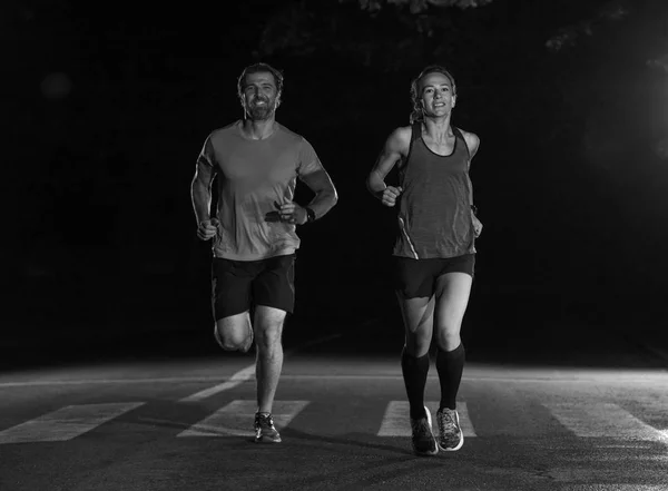 一组健康的人在城市公园慢跑 赛跑选手在夜间训练 — 图库照片