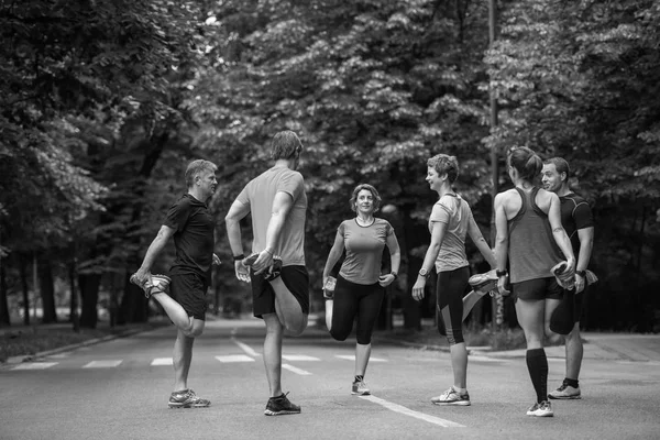 Equipo Corredores Sanos Calentándose Estirándose Parque Ciudad Antes Del Entrenamiento —  Fotos de Stock