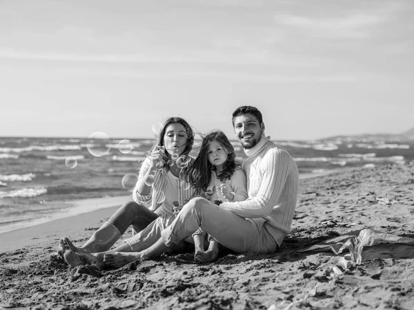 秋天里 有小女儿的家庭在海滩休息 开心地做肥皂泡沫 — 图库照片