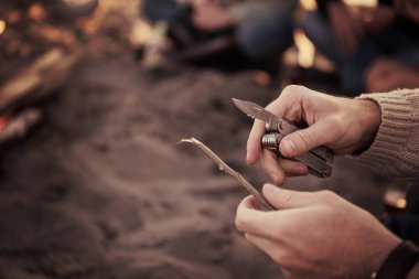 Mutlu tasasız genç arkadaşlar sahilde şenlik ateşiyle bira içip eğlenirken güneş filtrelemeye başlıyor.