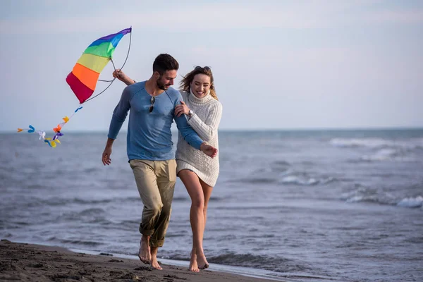 Pareja Joven Divirtiéndose Jugando Con Una Cometa Playa Día Otoño — Foto de Stock