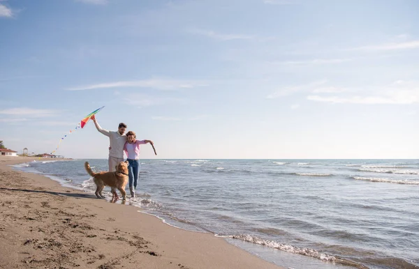 Genç Çift Eğlenmek Bir Köpek Sonbahar Günü Plaj Uçurtma Ile — Stok fotoğraf