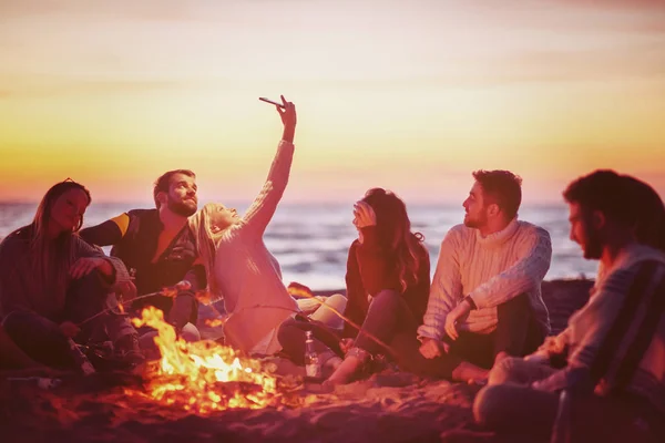 Grupo Amigos Usando Teléfonos Celulares Alrededor Hoguera Durante Fiesta Otoño —  Fotos de Stock