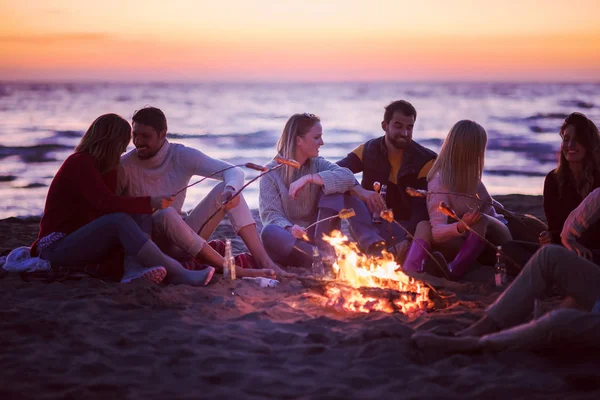 Gruppo Giovani Amici Seduti Accanto Fuoco Sulla Spiaggia Autunnale Grigliando — Foto Stock