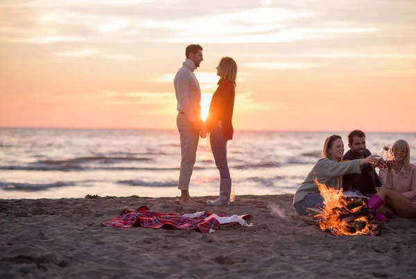 Pareja Joven Disfrutando Con Amigos Alrededor Campfire Playa Atardecer Bebiendo — Foto de Stock