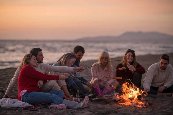 Grupo Jovens Amigos Sentados Lado Fogo Praia Outono Grelhando Salsichas — Fotografia de Stock