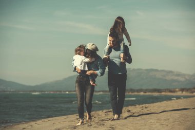 Sonbahar günü filtresi boyunca çocukların dinlendiği ve sahilde eğlendiği bir aile.