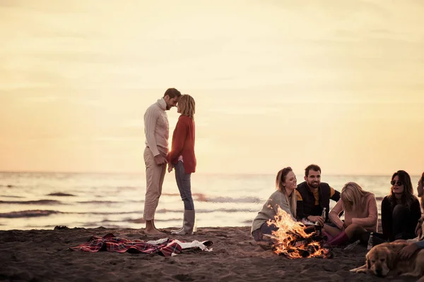 Giovane Coppia Godendo Con Gli Amici Intorno Fuoco Sulla Spiaggia — Foto Stock