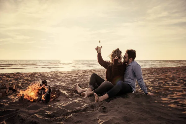 Young Couple Relaxing Fire Drinking Beer Drink Bottle Beach Autumn — Stock Photo, Image
