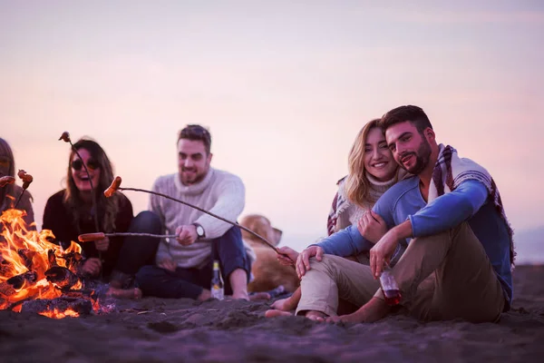 Grupo Jovens Amigos Sentados Lado Fogo Praia Outono Grelhando Salsichas — Fotografia de Stock