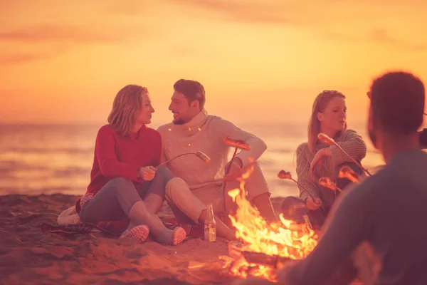 Gruppo Giovani Amici Seduti Accanto Fuoco Sulla Spiaggia Autunnale Grigliando — Foto Stock