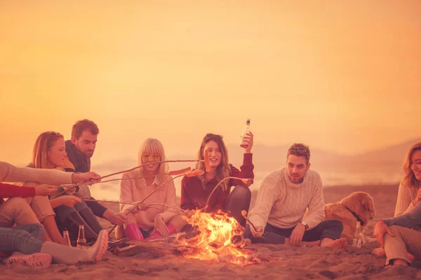 Group Young Friends Sitting Fire Autumn Beach Grilling Sausages Drinking — Stock Photo, Image