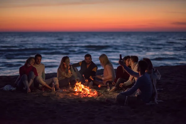 Grupo Amigos Usando Teléfonos Celulares Alrededor Hoguera Durante Fiesta Otoño — Foto de Stock