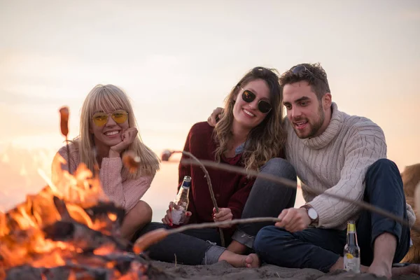 Gruppo Giovani Amici Seduti Accanto Fuoco Sulla Spiaggia Autunnale Grigliando — Foto Stock