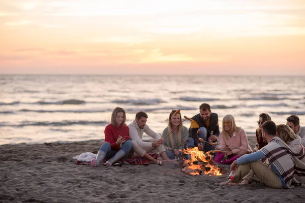 Grupo Jóvenes Amigos Sentados Junto Fuego Playa Otoño Asando Salchichas — Foto de Stock