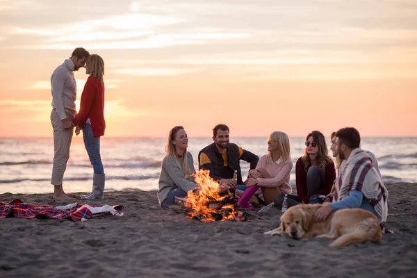 Casal Jovem Curtindo Com Amigos Redor Fogueira Praia Pôr Sol — Fotografia de Stock