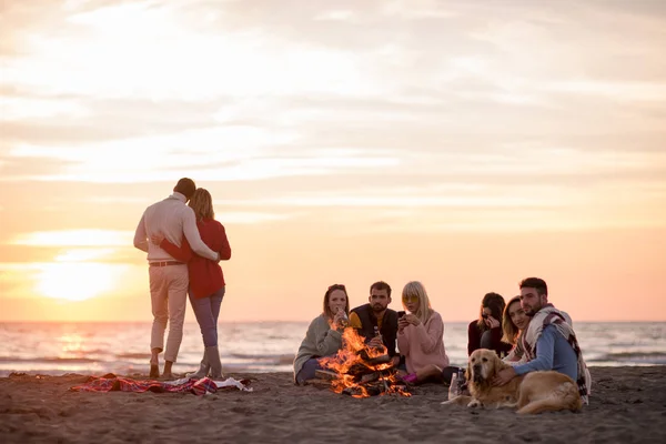 Casal Jovem Curtindo Com Amigos Redor Fogueira Praia Pôr Sol — Fotografia de Stock