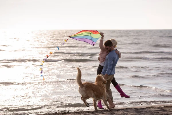 若いカップルが楽しんで犬 秋の日にビーチにカイトで遊んで — ストック写真