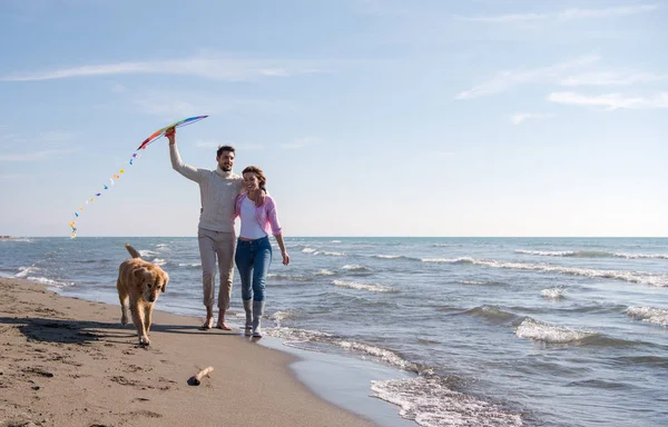 Młoda Para Zabawy Zabawy Psem Latawcem Plaży Jesienny Dzień — Zdjęcie stockowe