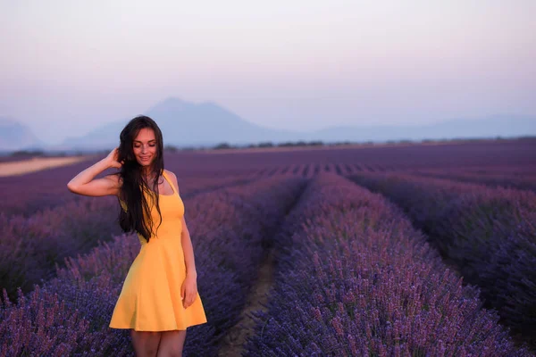 薰衣草妇女穿着黄色连衣裙 在紫色的田野上尽情放松 — 图库照片