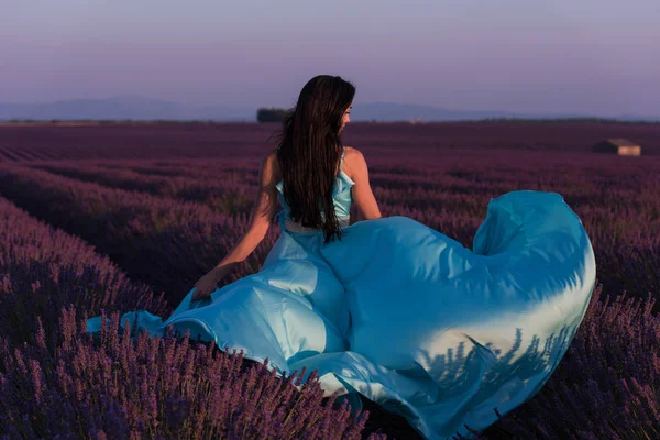 薰衣草花场妇女在 Cyand 礼服有乐趣和放松在风在紫色的花领域 — 图库照片
