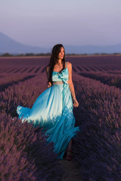 薰衣草花田野女子画像在 Cyand 礼服有乐趣和放松在风在紫色的花领域 — 图库照片