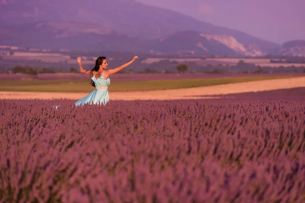 薰衣草花场妇女在 Cyand 礼服有乐趣和放松在风在紫色的花领域 — 图库照片